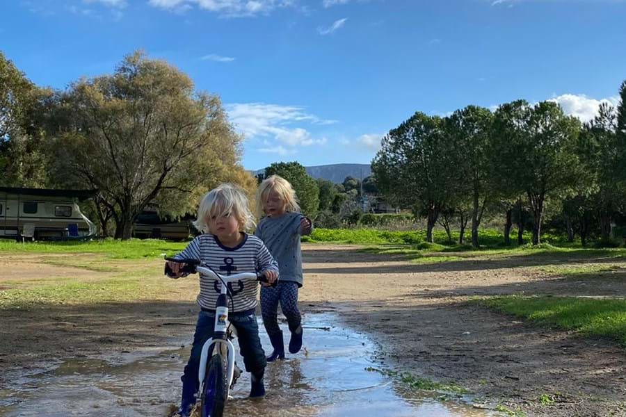 kinderen fietsen door modder