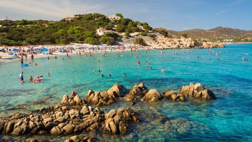 Toeristen aan de kust porto Giunco in Sardinië