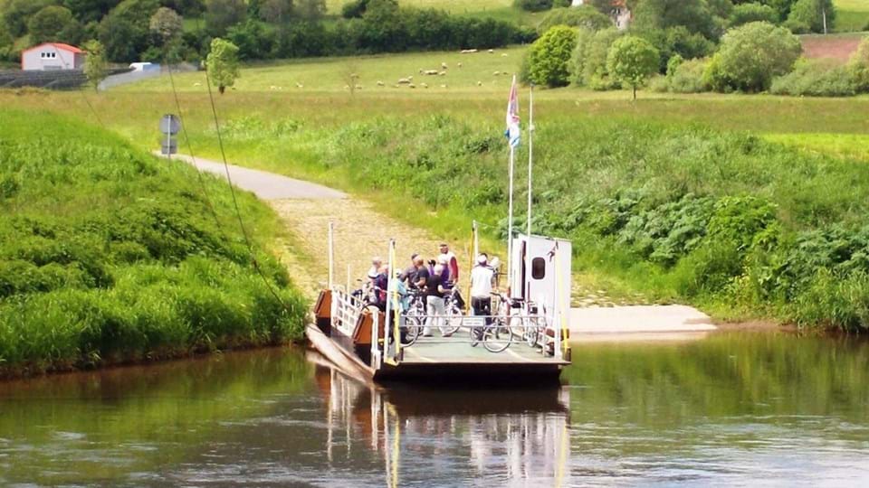 Mensen en fietsen op een pont in Oost-Duitsland