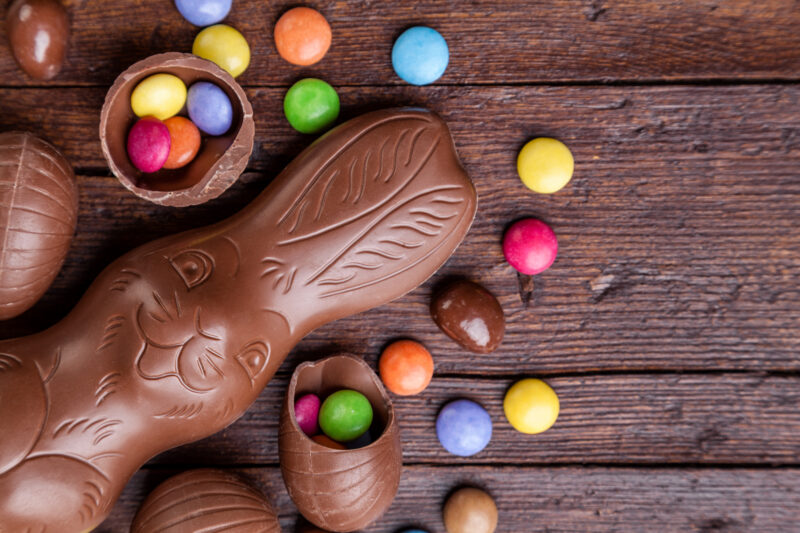 Chocolate easter eggs and sweets on wooden background