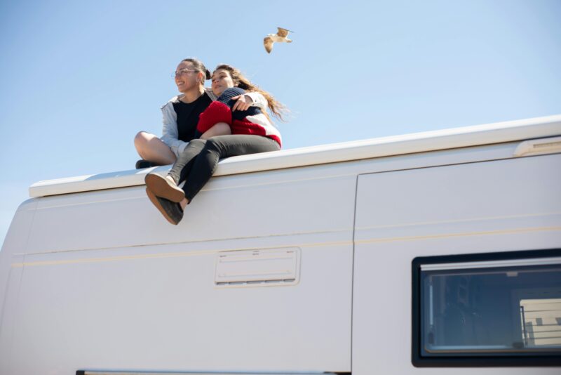 Kinderen zitten op het dak van een camper
