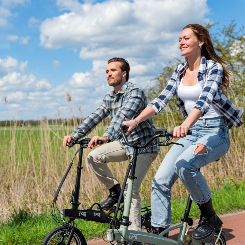 Man en vrouw rijden op hun EMQ elektrische vouwfiets