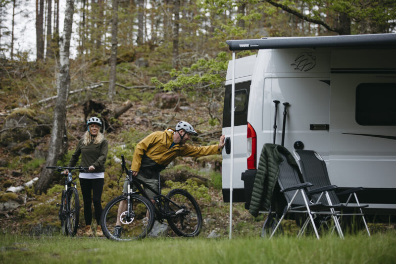 Twee fietsers staan bij een camper in Småland
