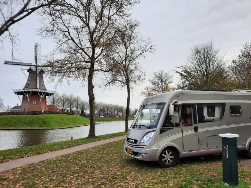 Camper bij het water in Dokkum, op achtergrond een molen