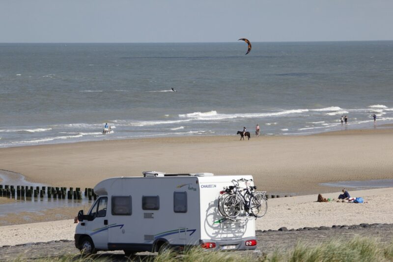 Een strand in Zeeland met op de voorgrond een camper