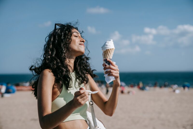 vrouw op het strand eet ijsje