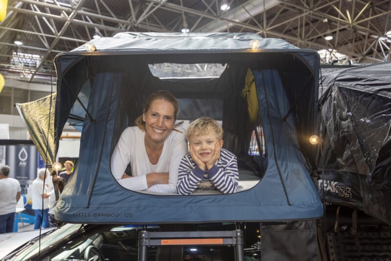 Moeder en kind in tent op camper